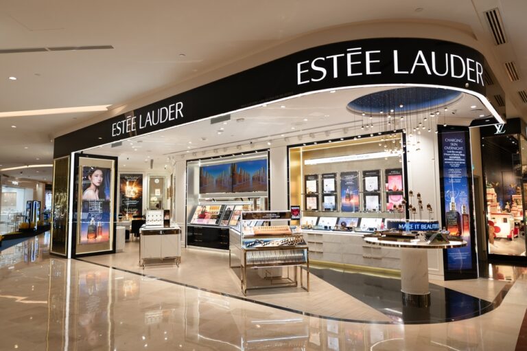 Estée Lauder s prvými kozmetickými výrobkami na stole, symbolizujúca začiatky ikonickej značky.
